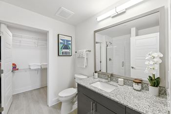 A bathroom with a large mirror and a toilet and a sink